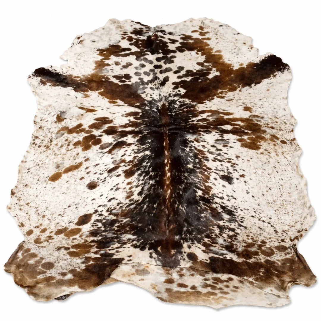 Natural brown and white cowhide rug with unique spotted pattern on white background