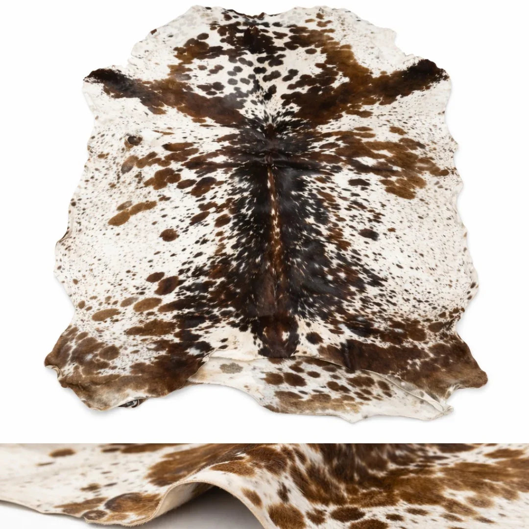 Natural cowhide rug with brown and white spotted leather pattern on white background