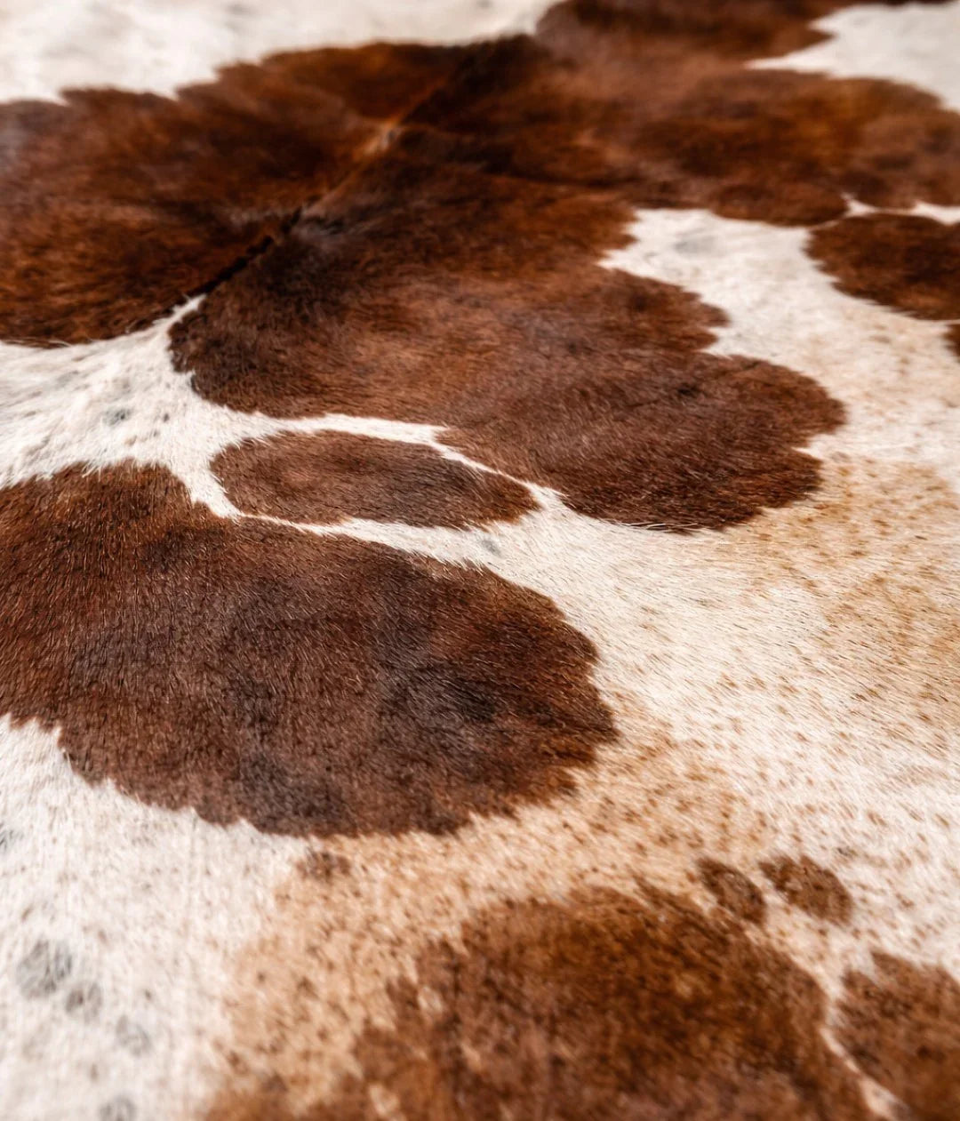 Close-up of brown and white cowhide leather rug texture