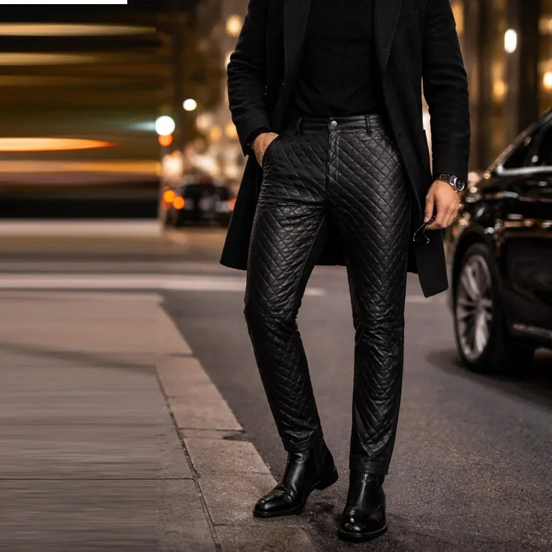 Men's black genuine leather pants with slim fit quilted design, worn on city street at night