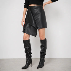 Woman wearing black genuine leather asymmetrical skirt and knee-high leather boots