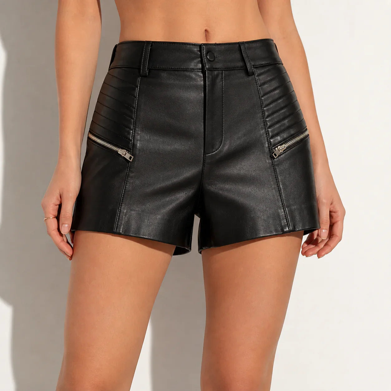 Women's black genuine leather shorts with zipper pockets and quilted details