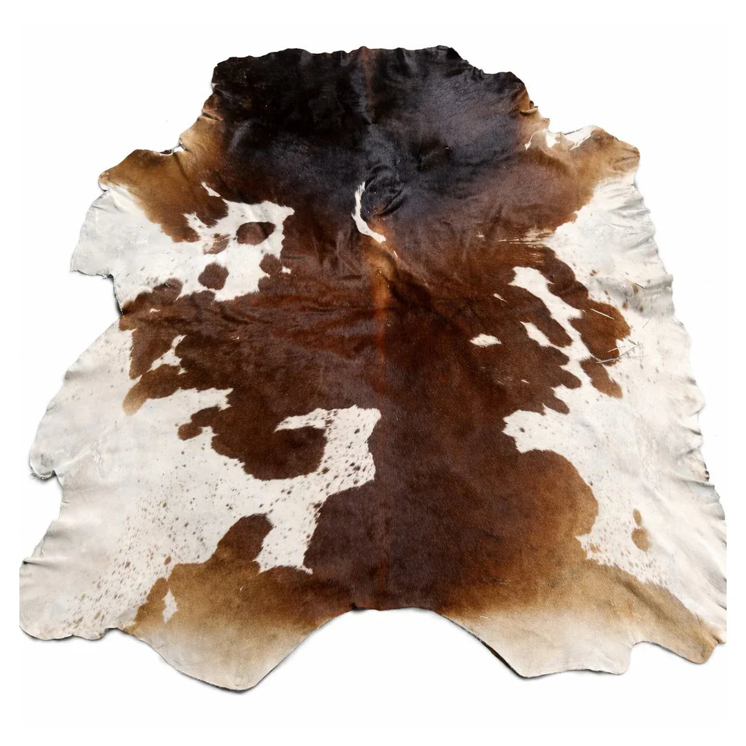 Brown and white cowhide leather rug with natural markings on white background