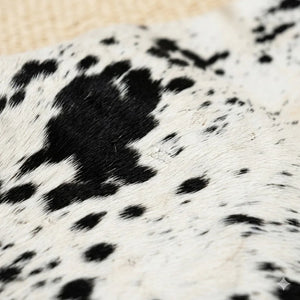 Close-up of genuine cowhide leather rug with black and white spotted pattern