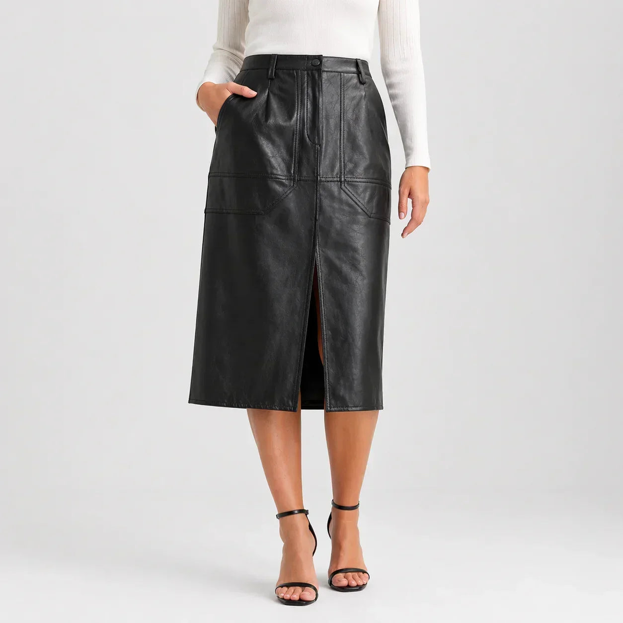 Black genuine leather midi skirt with front slit, worn by woman in white top and heels