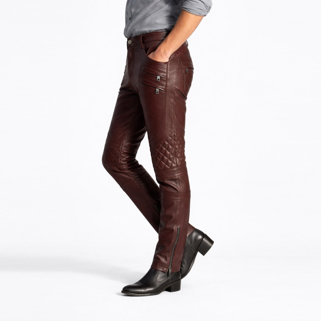 Men's brown leather pants with quilted knee detail and zippered pockets, styled with boots.