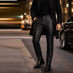 Men's black genuine leather pants with slim fit quilted design, worn on city street at night