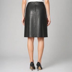 Woman wearing black genuine leather skirt and black heels, rear view, studio background