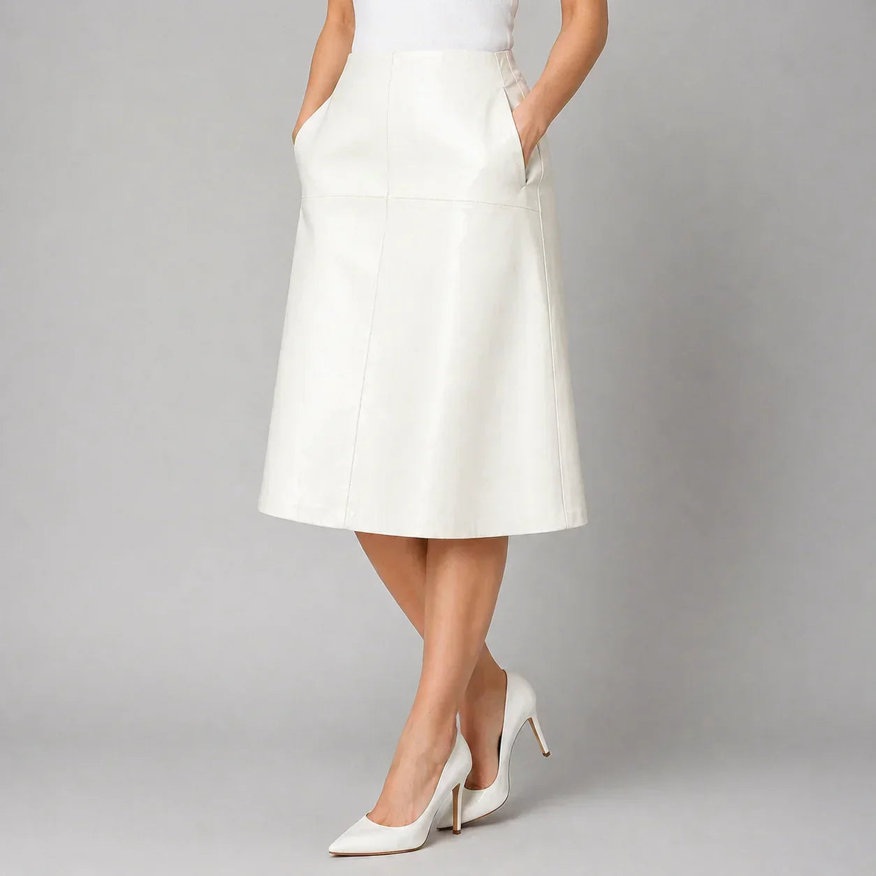 White genuine leather A-line skirt with side pockets, styled with white heels