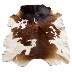 Brown and white cowhide leather rug with natural markings on white background